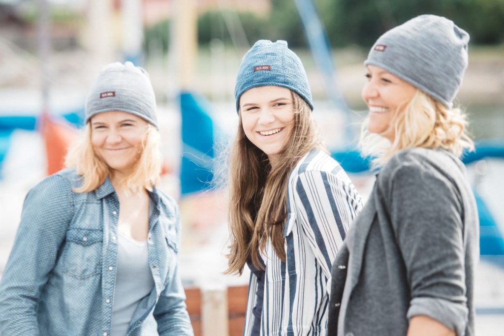 Kolm naist KAMA suvemütsides sadamakail